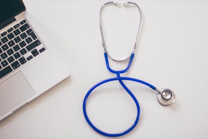 Laptop and stethoscope on a desk representing how to vet an online telehealth weight-loss program before paying