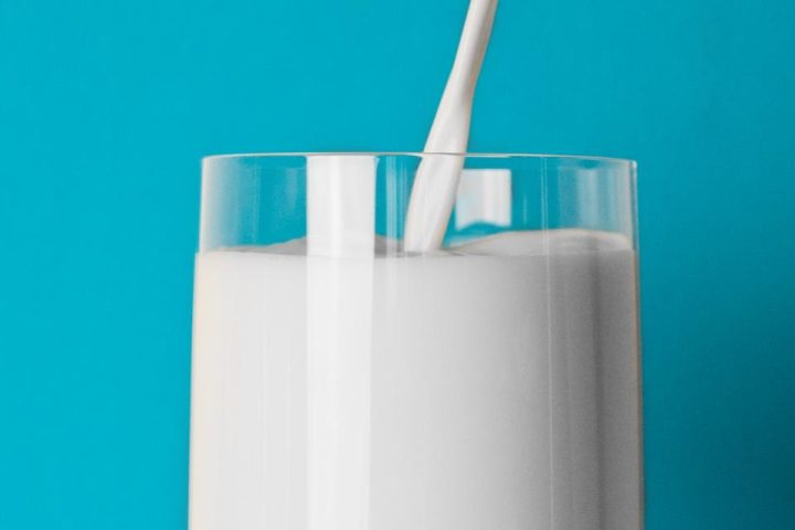 Milk pouring into a tall glass, the natural source of both casein and whey